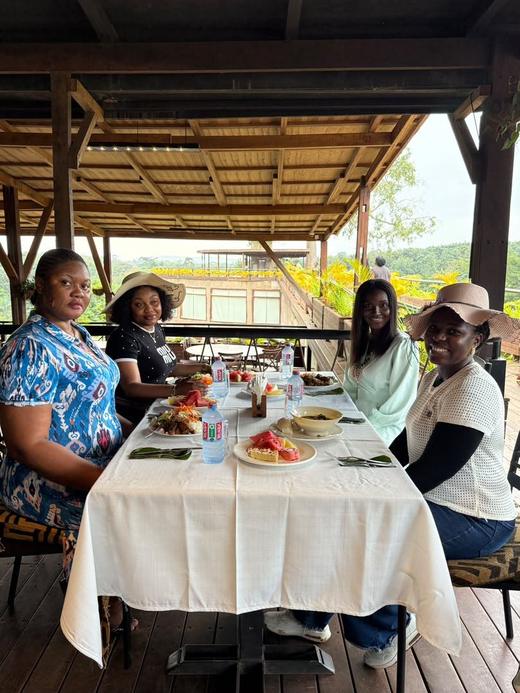 Guests sharing lunch around a table on a covered terrace.