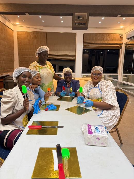 Guests in aprons and hairnets ready for the cake decoration session.